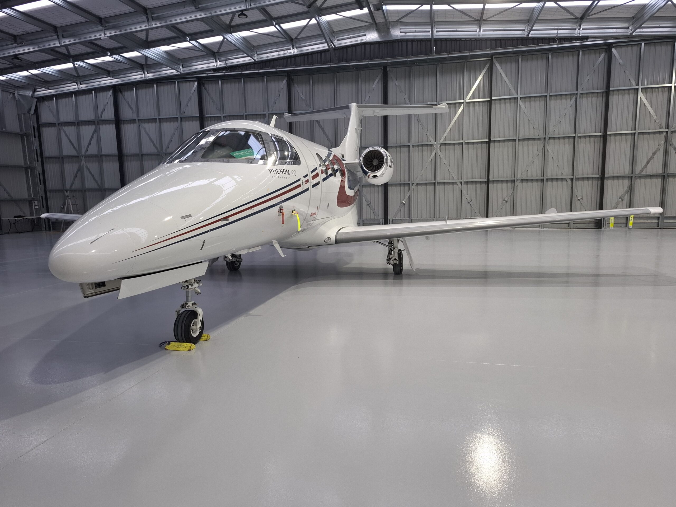 Private jet in a hangar with banner text 'New jet and helicopter hangar opening mid-2022